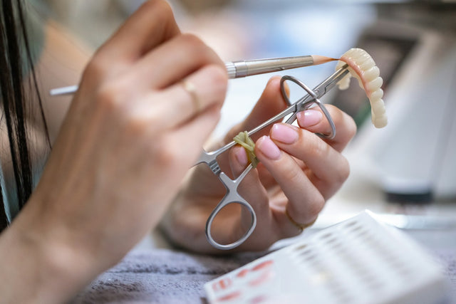 Technician finishing a dental restoration with fine tools