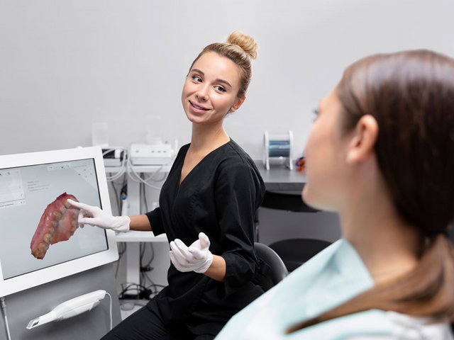 Dental assistant showing a patient a digital scan