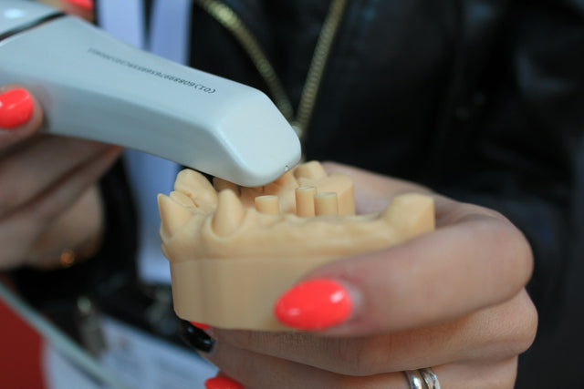 Intraoral scanner over a stone model of a dental arch