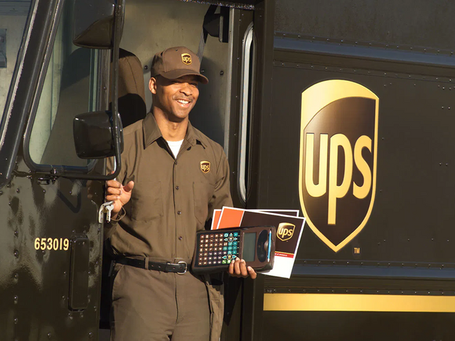 UPS driver holding a delivery scanner and envelopes