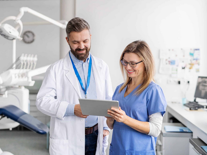 Dentist and assistant reviewing a digital case on a tablet